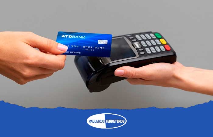 Persona pagando con tarjeta de crédito y terminal bancaria