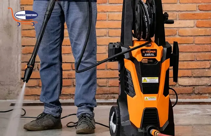 Hombre limpiando el suelo con una hidrolavadora
