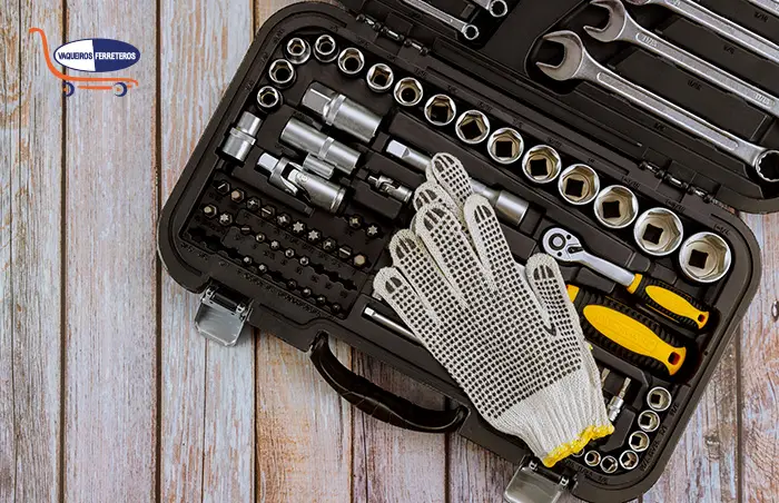 Kit de herramientas para mecánico con guantes de trabajo sobre una mesa de madera