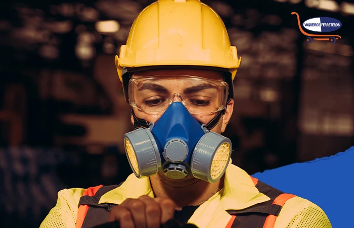 Vista frontal de la cabeza de un trabajador que está usando un tipo de EPP respiratoria, gafas de seguridad, casco y ropa reflejante.