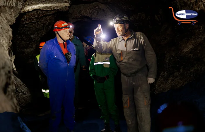 Varios trabajadores dentro de una mina, todos ellos usan su epp. El uso de este equipo es de carácter obligatorio en industrias con muchos riesgos como la minera.