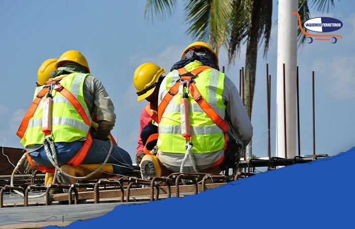 Trabajadores colocando el acero armado de una construcción en un inmueble alto. Todos usan los distintos tipos de EPP para las alturas que hay.