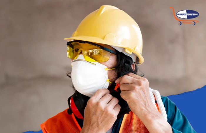 Trabajador terminando de ajustarse el casco, también usa mascarilla, ropa reflejante y epp ocular.